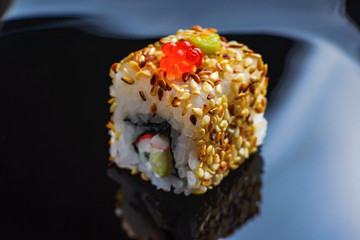 Sushi rolls Japanese cuisine in the restaurant. Sushi on a black background, caviar, closeup. Japanese restaurant menu