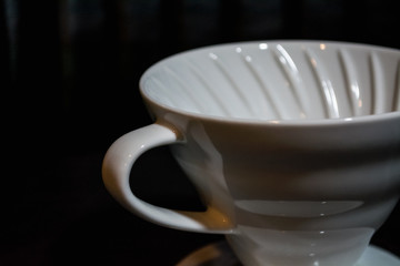 White funnel Pourover on a black background for preparation of coffee by an alternative method. Work the barista in coffee shop. 