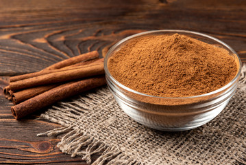 Cinnamon on dark wooden background. 