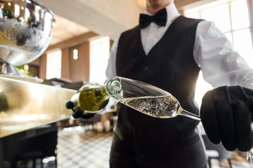 sommelier pours wine into a glass