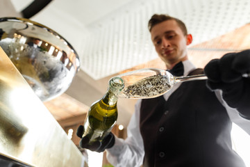 sommelier pours wine into a glass