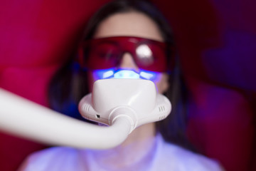 girl in the chair on the procedure of teeth whitening.