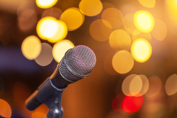 Microphone against festive lights, space for text. Musical equipment