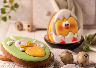 easter cookies with painted easter bunny and chicken near decorative buffet and napkin on white cutting boards and wooden background