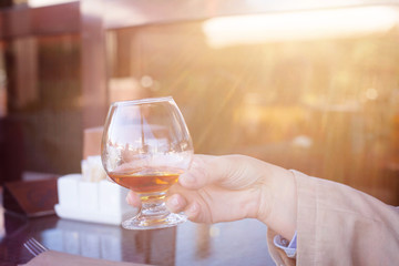 Glass of brandy in hand in the sun