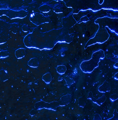 Ice on blue glass as abstract background