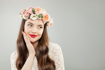 Young woman in summer flowers wreath. Pretty model with red lips makeup and cute smile portrait