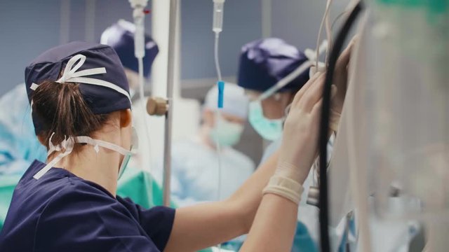 Female anesthesiologist examining all the parameters 