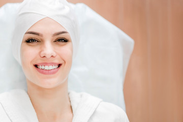 Smiling girl in the office at the beautician, ready for the procedure on the face. Rejuvenation, face lift.
