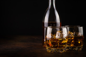 Whiskey in the glasses on dark background. 