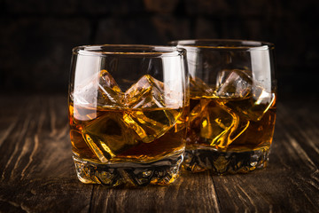 Whiskey in the glasses on dark background. 