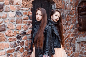 Twins sisters outside in autumn. Fashion look