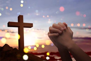 Christian cross and male hands with praying position