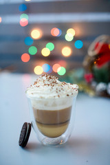Coffee drink with milk and cookies on the table. Bokeh lights.