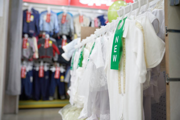 White t shirt for kids on hangers in clothing store.