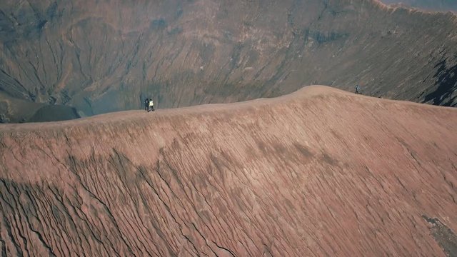 View of a couple on Mount Bromo, is an active volcano and part of the Tengger massif, in East Java, Indonesia near Bali dangerous