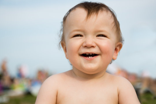 Portrait of a smiling little boy resting on beach