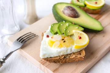 egg ,avocado and sesame sandwich on a chopping Board