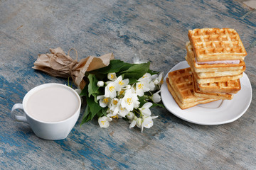 Romantic breakfast. Bouquet of jasmine. A cup of hot cocoa and Belgian waffle.