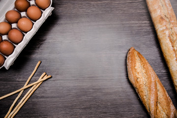 Flat lay top view of loaves of bread, sticks of bread an dozen of eggs.