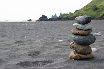 Fototapeta na wymiar Stack of pebble stones at the black sand beach in the south of Iceland
