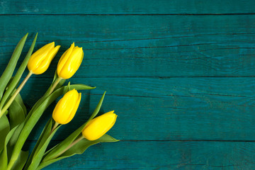 Beautiful, fresh yellow tulips on wooden background