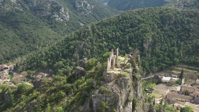 Flying around old castle ruins on a cliff. Saint Guilhem le Desert medieval villages Unesco site France