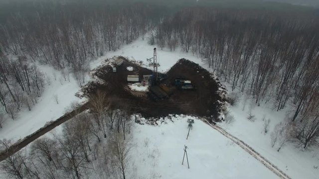 Drilling a deep well with a drilling rig in an oil and gas field in winter forest. The field is located in Kamchatka, Tundra, Yamal, North, West, Siberia, fog, smoke, aerial
