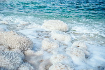 .incredibly beautiful seaside of the dead sea with blue water and white crystals of salt near.selective focus