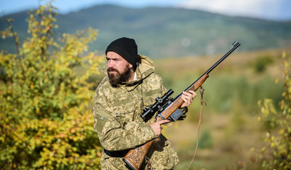 Hunter hold rifle. Bearded hunter spend leisure hunting. Focus and concentration of experienced hunter. Regulation of hunting. Hunting masculine hobby concept. Man brutal gamekeeper nature background