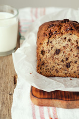 Banana cake on a wooden background with a glass of milk