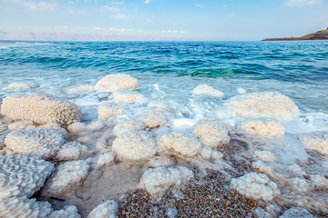 .incredibly beautiful seaside of the dead sea with blue water and white crystals of salt...