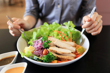 Healthy woman eating salad with chicken breast slices healthy lifestyle concept.