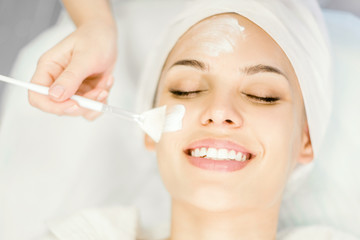 Cosmetology. Close-up application of cleansing facial mask with a brush.