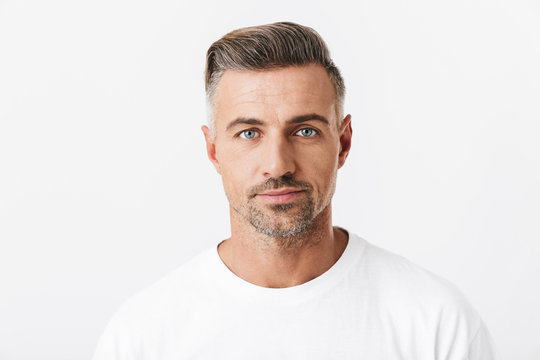 Image of confident man 30s with bristle wearing casual t-shirt posing and looking on camera