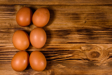 Pile of the hen eggs on wooden table. Top view