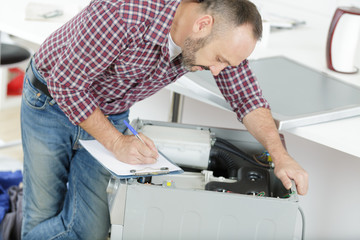 plumber fixing domestic washing machine