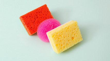 Assortment of bright scouring sponges on green surface.Concept of products for house cleaning.Different colors 