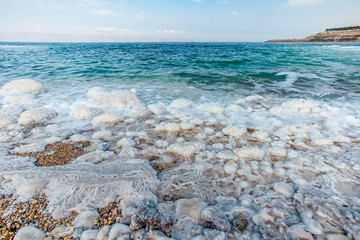 .incredibly beautiful seaside of the dead sea with blue water and white crystals of salt...