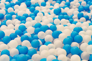 Close up of plastic white and blue balls in dry pool on the playground