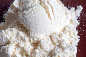 Heap of yellow banana protein powder on dark background. Top view