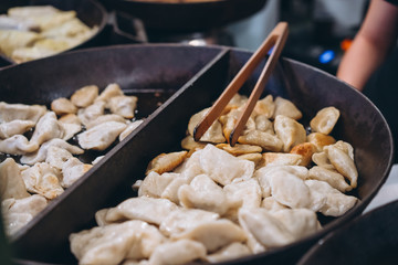 Dumplings with meat, onions on a big cast iron skillet.