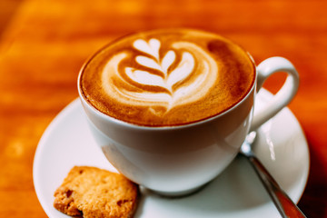 cup of coffee with whipped cream on wooden background