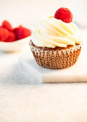 cupcake and raspberry, marble backdrop, light background