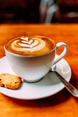 cup of coffee with whipped cream on wooden background