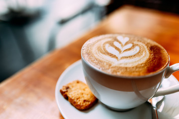 cup of coffee with whipped cream on wooden background