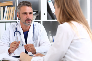 Smiling handsome mature doctor communicate with patient