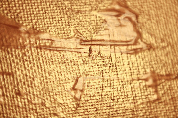 golden acrylic paint on textured canvas background