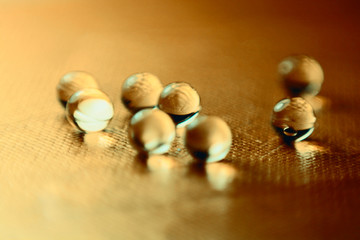 heap of round pills on golden metallic background