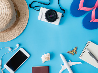 top view travel concept with digital camera, smartphone, map, passport, compass and Outfit of traveler on blue background, Tourist essentials, vintage tone effect